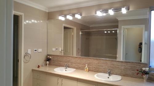 珀斯Vimal's Homestay的一间带两个盥洗盆和大镜子的浴室