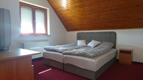塞克希费黑瓦尔Flamingó Panzió的一间卧室设有一张木天花板床。