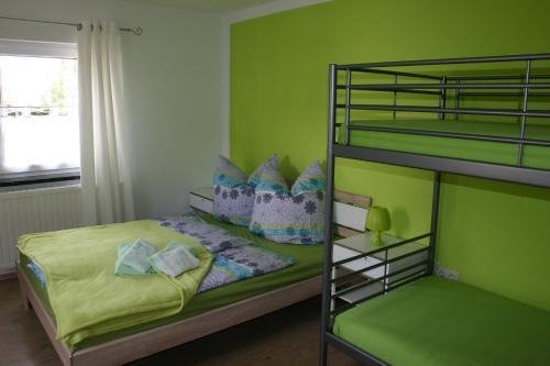 塞布尼茨Ferienhaus Sonneneck的绿色卧室设有双层床和绿色的墙壁