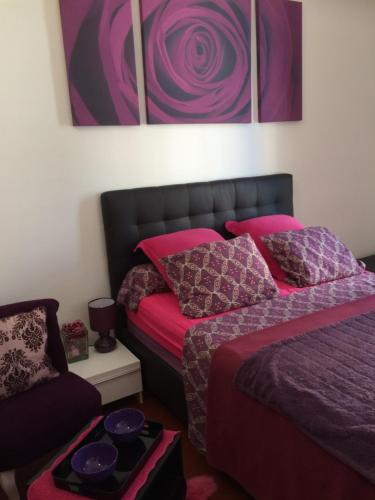 芒通Chambres dans guest house Centre ville的一间卧室配有两张带粉色和紫色枕头的床