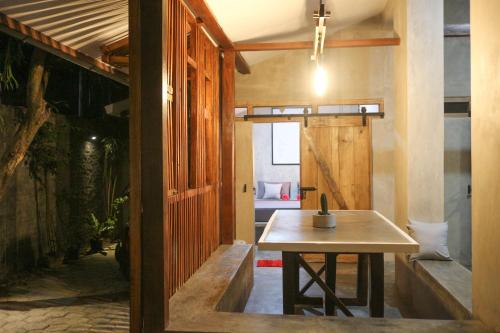 日惹特拉瓦度假屋的一间房间,里面设有桌子和长凳