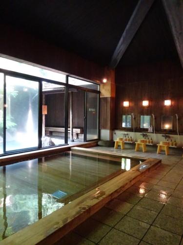 松江市科尼亚酒店的一座带大窗户的建筑中的游泳池