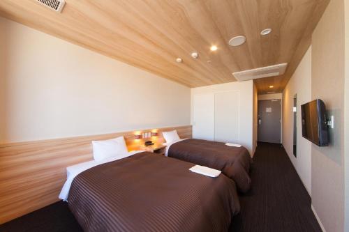 泉佐野泉佐野中心关西国际机场酒店的酒店客房设有两张床和一台平面电视。