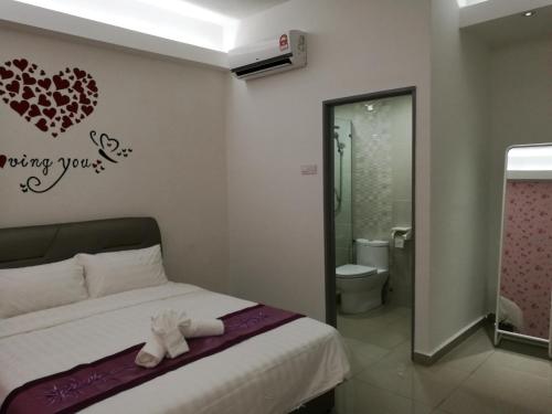 马六甲D舒适酒店的卧室配有一张位于墙上的床铺。