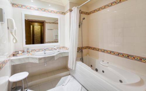 托泽尔托泽尔艾尔姆哈迪酒店的白色的浴室设有浴缸、水槽和浴缸。