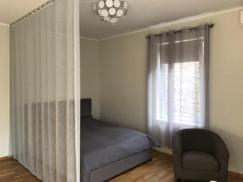 塔林Apartment in Kalamaja的卧室配有床、椅子和窗户。