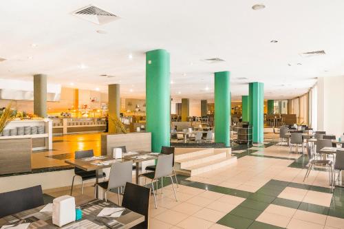 阳光海滩卡利纳花园MPM酒店 - 全包的餐厅设有绿色柱子和桌椅