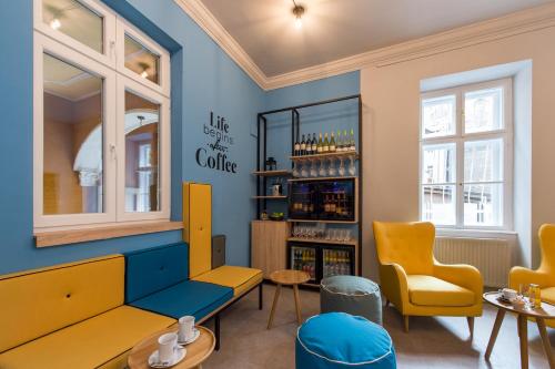 布达佩斯Three Corners Hotel Anna的餐厅设有黄色椅子和蓝色的墙壁