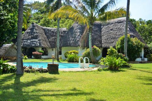 蒙巴萨Fast Care Villa Bavaria的热带房屋 - 带游泳池和棕榈树