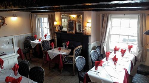 阿布罗斯The Old Brewhouse的餐厅设有红色餐巾桌