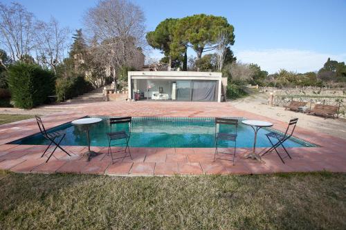 雷乌斯Mas del Molí的房屋前设有2张桌子和椅子的游泳池