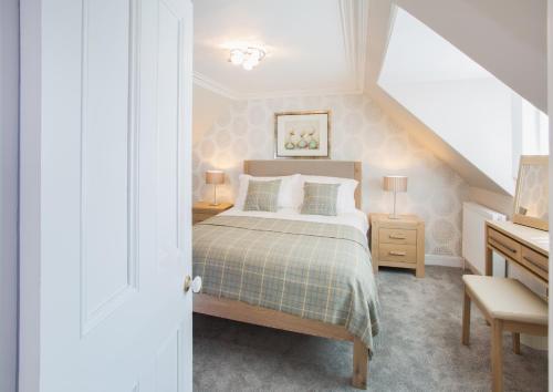因弗内斯Shore View Cottage的一间卧室配有一张床和一张带两盏灯的书桌。