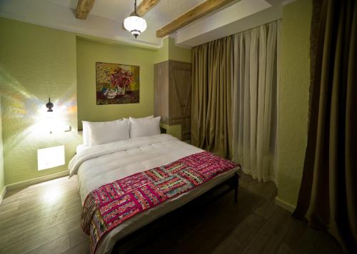 第比利斯十二号精品酒店的一间卧室设有一张大床和一个窗户。