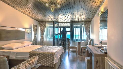 阿克恰科贾Akcakoca Poyraz Otel的一间酒店客房,配有一张床和一个女士,从窗户望出去