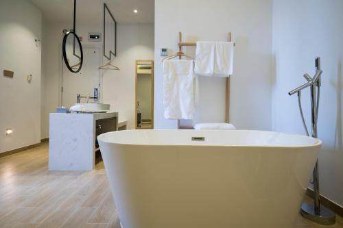潮州潮州上水门边客栈的浴室配有白色浴缸及水槽