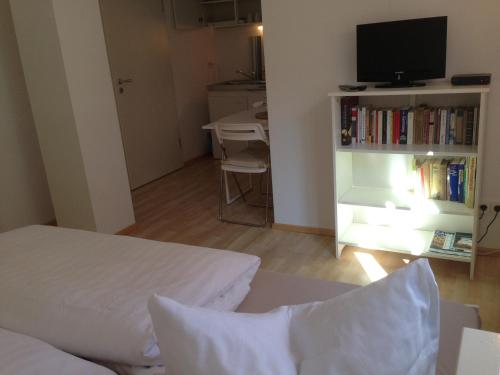 巴登-巴登Petite Bellevue II的一间卧室配有一张床、一台电视和一张桌子