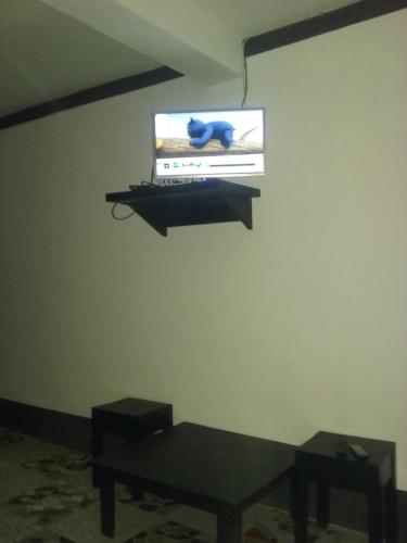 IvatoVilla Cassis的墙上的电视,房间带桌子