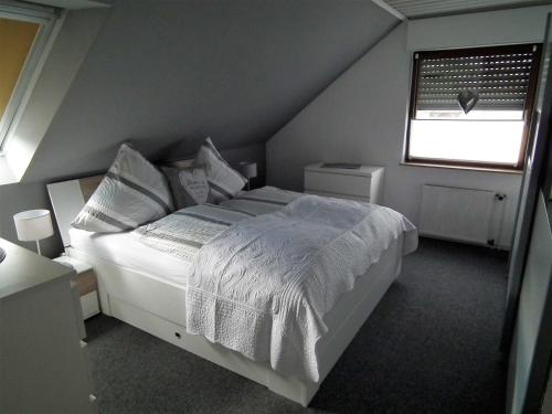 格尔德恩Komfort_Ferienwohnung的卧室配有白色的床和窗户。