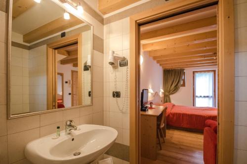拉比方塔宁旅馆的一间带水槽的浴室和一间带一张床的卧室