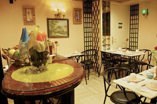 巴黎巴黎伏尔泰酒店的一间带桌椅和一瓶水果的餐厅