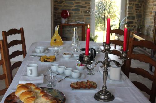 Ardevon小山住宿加早餐旅馆的一张桌子,上面有白色的桌布,上面有食物和蜡烛