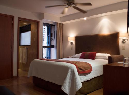 墨西哥城吉洛酒店的一间卧室设有一张大床和一个窗户。
