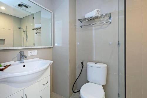 登巴萨彭多克奈曼15号旅馆的一间带水槽、卫生间和镜子的浴室