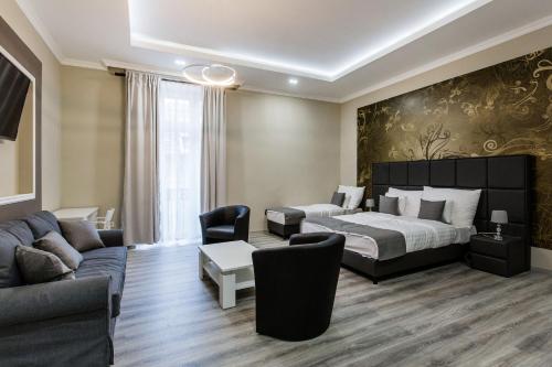 布达佩斯A Golden Star Modern Luxury Apartments and Suites Budapest的酒店客房,配有床和沙发