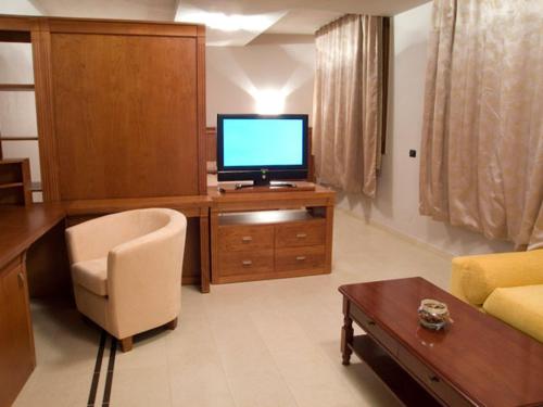 阿拉德Hotel Gio的客厅配有木桌上的电视