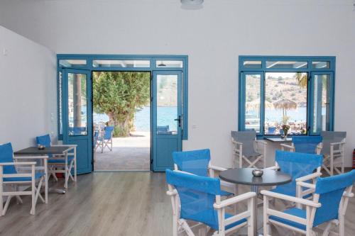斯科拉Delfini Hotel的一间设有蓝色椅子和桌子的用餐室以及窗户。