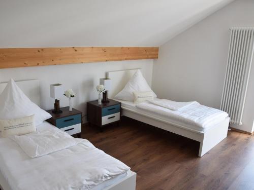 巴特比恩巴赫Ferienwohnung Leni的一间卧室设有两张床和两个床头柜