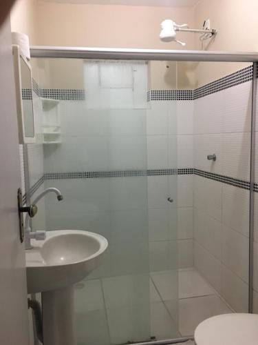 热基耶Hotel Real Jequie的一间带玻璃淋浴和水槽的浴室
