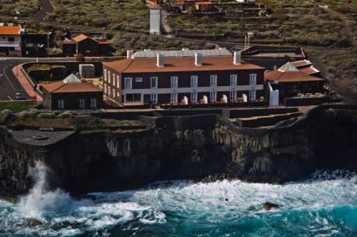 Sabinosa巴尔内阿里奥波索德拉萨卢德酒店的海边悬崖上的建筑