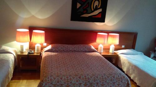 斯特拉斯堡欧朗吉里酒店的一间卧室配有两张床和两盏灯。