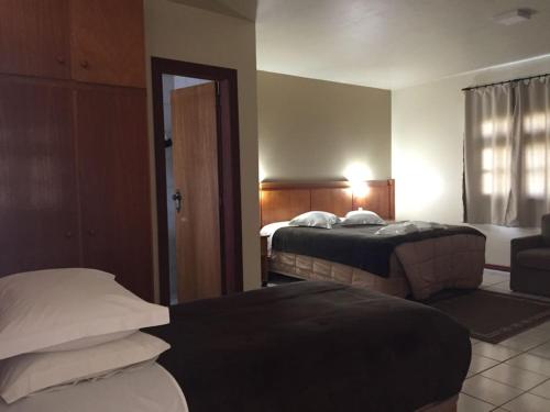 拉热斯Villa Apart Hotel的酒店客房设有两张床和窗户。