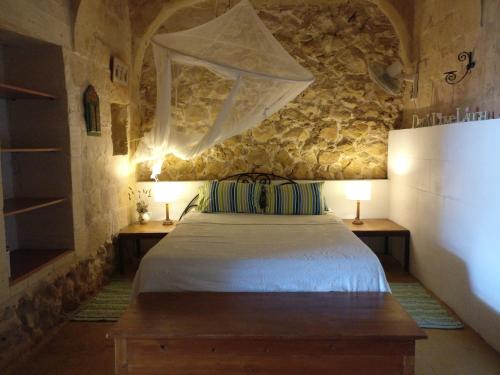 加斯利Farmhouse Dhyana的一间卧室配有一张带两张桌子和两盏灯的床。