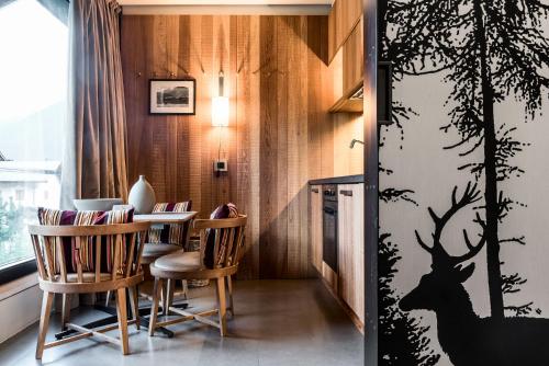 博尔米奥Eden Hotel的一间用餐室,配有桌子和墙上的鹿纹