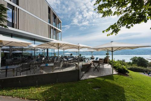 吕施利孔贝尔沃瑞士优质酒店的一间带桌椅和遮阳伞的餐厅