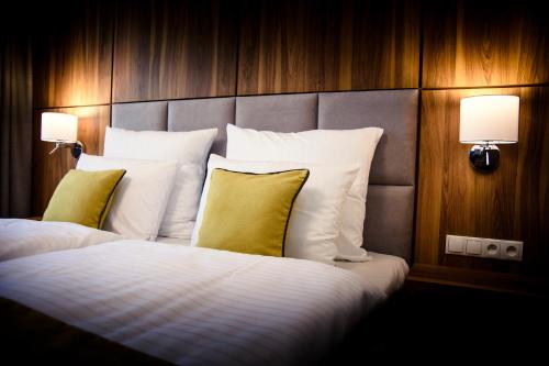 绿山城锡隆纳葛拉鲁本酒店的酒店客房配有带白色床单和黄色枕头的床。