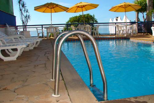 伊利利达麦美亚宾馆的一个带遮阳伞和椅子的游泳池以及游泳池
