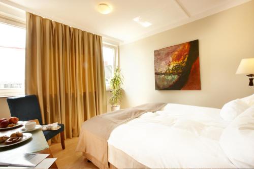 基尔Premiere Classe Hotel am Kieler Schloss Kiel的卧室配有白色的床、桌子和窗户。