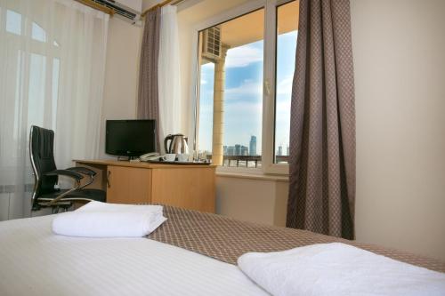 巴库老城酒店的一间卧室配有一张床、一张书桌和一个窗户。