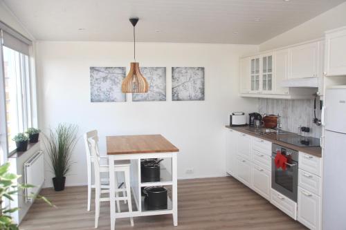 VegamótLynghagi House的厨房配有白色橱柜和木桌