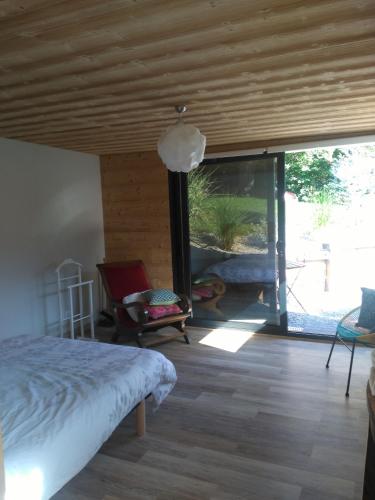 杜萨尔Le chalet du Lac的一间卧室设有一张床和一个大型滑动玻璃门