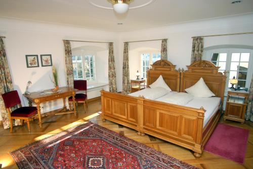 瓦杜兹雄狮客栈酒店的一间卧室配有一张大木床和一张书桌