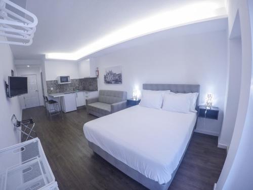 巴塔拉Mosteiro View的一间带白色大床的卧室和一间厨房