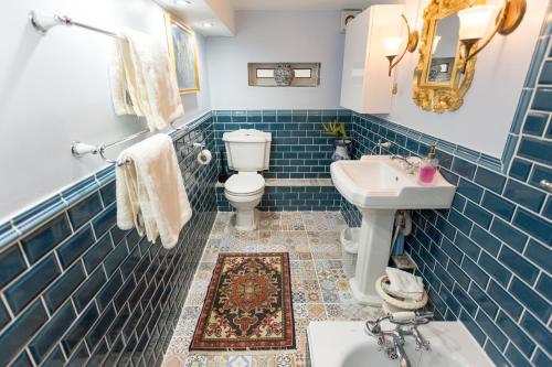 曼彻斯特雅诗阁服务公寓的蓝色瓷砖浴室设有卫生间和水槽