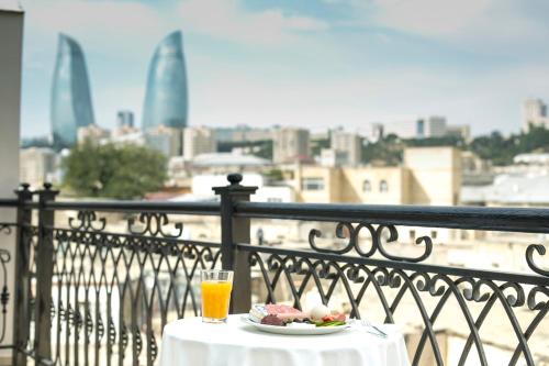 巴库老城酒店的阳台上的桌子上放着一盘食物和饮料