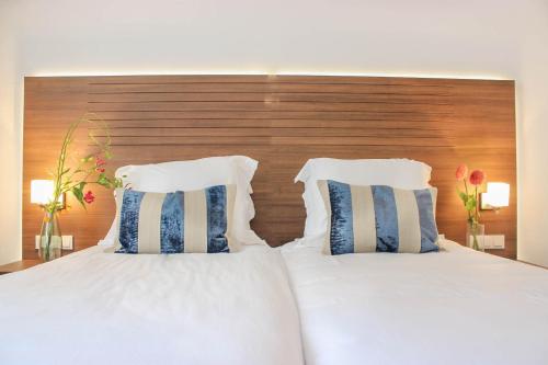 奥斯特豪特A-Hotel Oosterhout的一间卧室配有两张白色的床和木制床头板