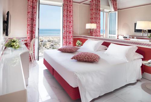 里米尼里米尼米尔顿酒店的一间卧室设有一张大床和一个大窗户
